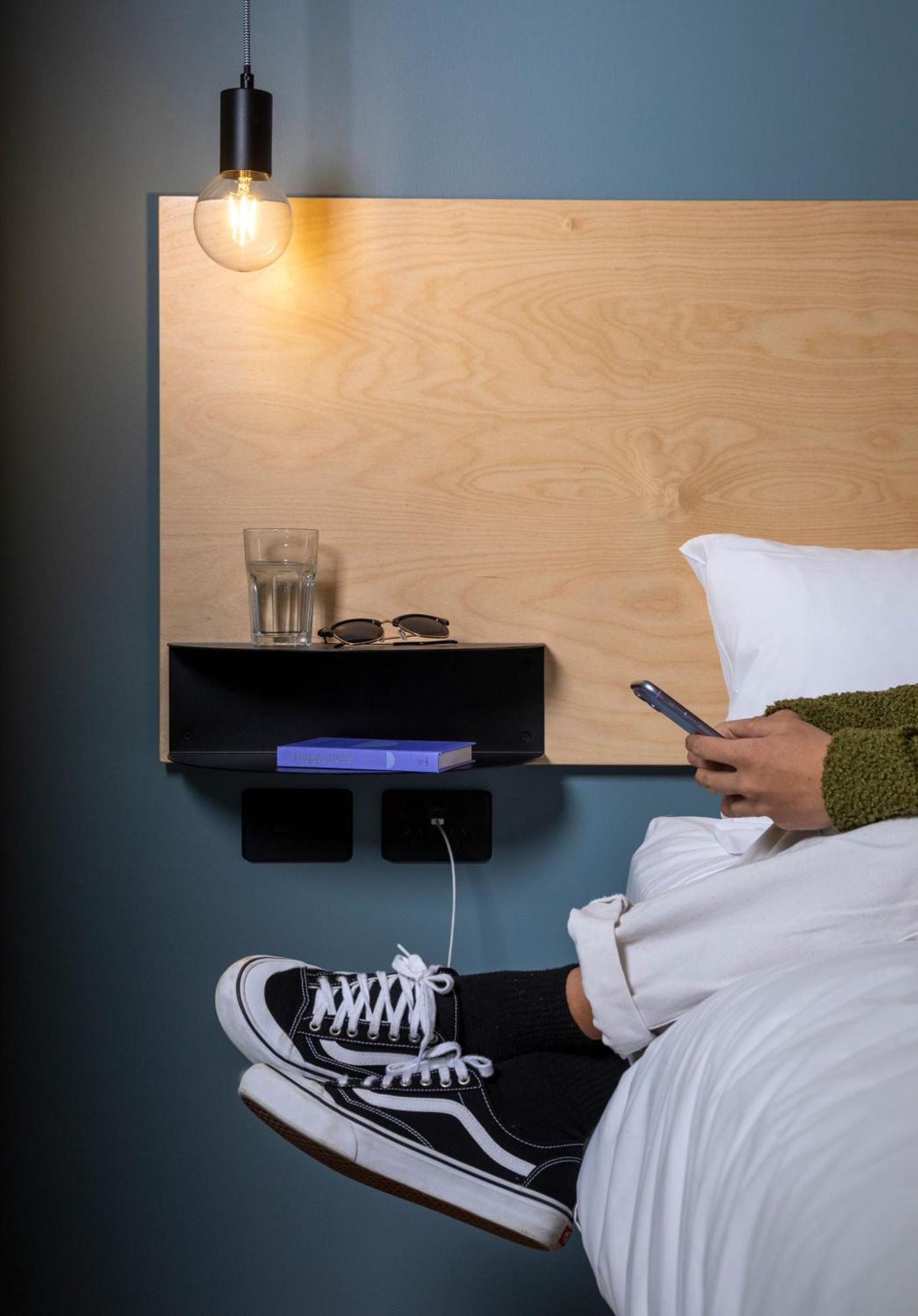 Lylo Auckland Hotel Стая снимка A phone being used in bed